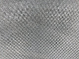 A close-up of a gray fabric with holes, revealing its intricate texture and unique pattern.