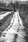 Vintage image of a man in overalls working on a farm, black and white