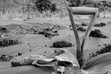 A shovel resting in the dirt on a biodegradable cornstarch film